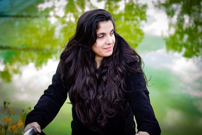 Young woman looking away while standing outdoors