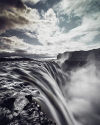 Scenic view of mountains against cloudy sky