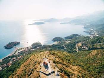 High angle view of sea and mountains against sky