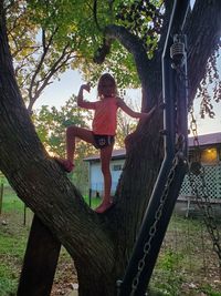 Full length of girl on tree trunk