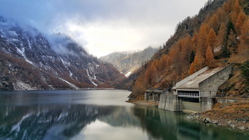 Scenic view of lake by mountains against sky