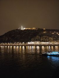 Scenic view of illuminated sea against sky at night