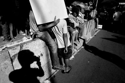 Low section of people walking on footpath in city