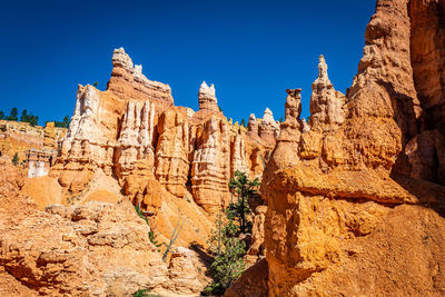 Low angle view of rocks against blue sky