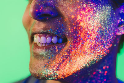 Close-up of man with multi colored face paint