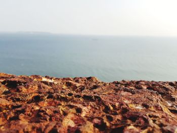 Surface level of rocks on beach against sky