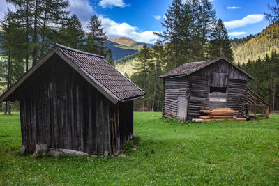 House amidst trees on field against sky