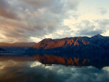 Scenic view of lake by mountains against sky