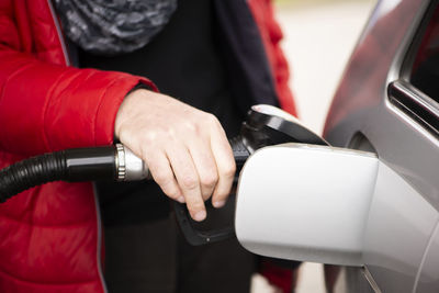 Hand refilling the car with fuel at the refuel station