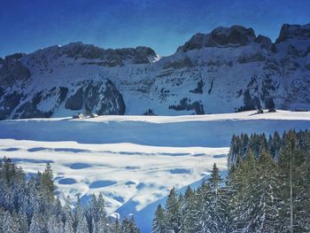 Scenic view of frozen lake against blue sky