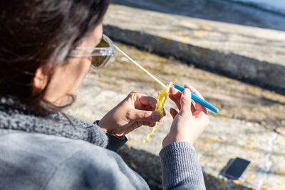 High angle view of woman knitting with thread