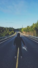 Rear view of man on road against sky