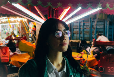 Close-up of young woman against carousel