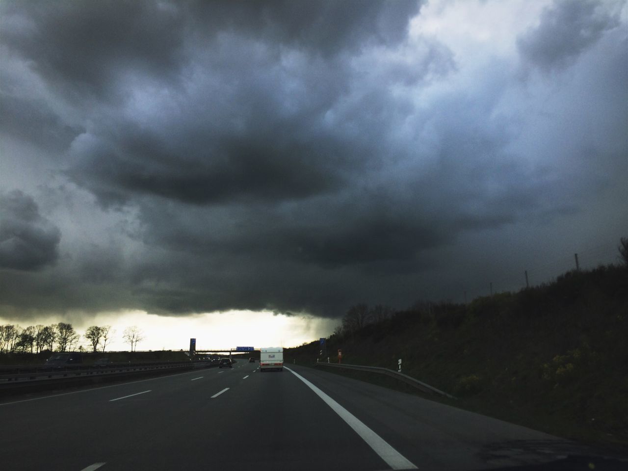 ROAD PASSING THROUGH STORM CLOUDS OVER DRAMATIC SKY