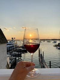 Man holding drink at sunset