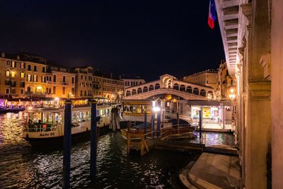 Canal amidst illuminated city against sky at night