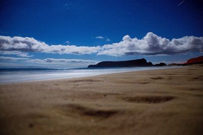 View of calm beach against blue sky