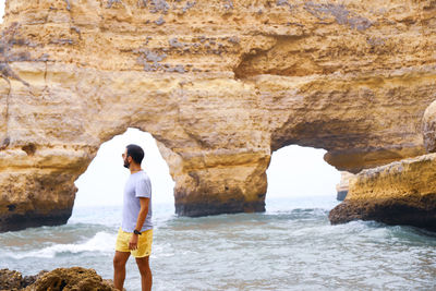 Full length of man standing on rock at beach