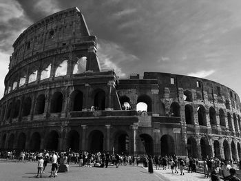 Tourists at historical building against sky