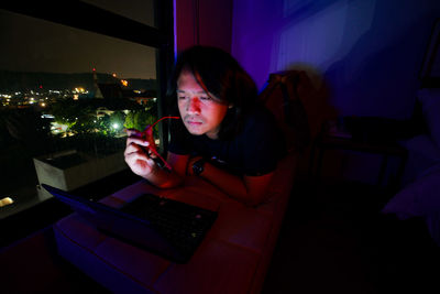 Young woman using mobile phone at home