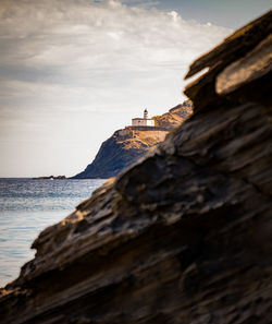 Rock formations by sea against sky