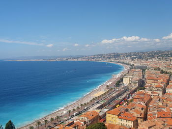 Aerial view of townscape by sea against sky