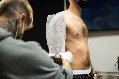 Rear view of man and woman standing at home