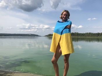 Rear view of woman standing at lake