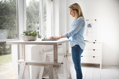 Young woman using mobile phone at home