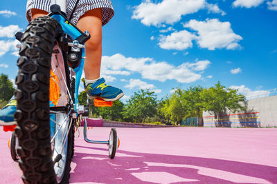 Low section of man riding bicycle on street