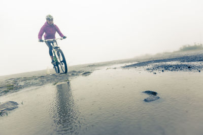 Man riding bicycle on beach