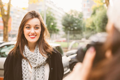 Portrait of smiling young woman in city