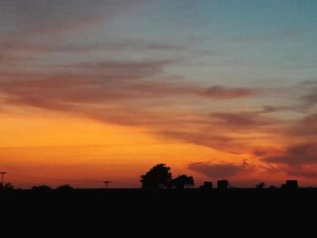 Silhouette landscape against dramatic sky during sunset