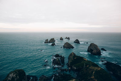 Scenic view of rocks in sea against sky