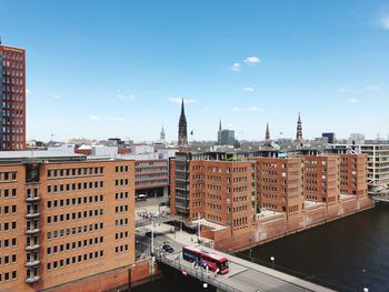 High angle view of buildings in city against blue sky