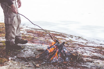 Man making sausage over open fire