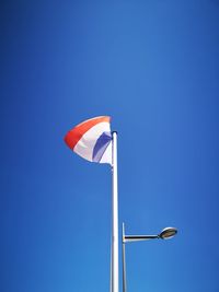 Low angle view of street light against clear blue sky and french flag