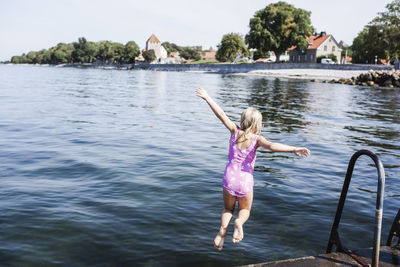 Girl jumping into sea