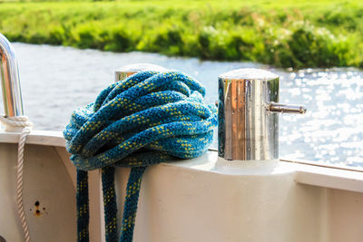 Close-up of rope tied to blue water