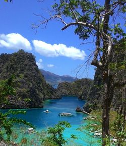 Scenic view of sea and mountains against blue sky