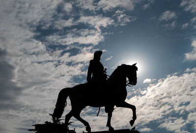 Silhouette man riding horse