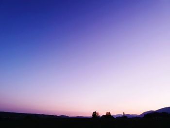 Silhouette landscape against clear sky during sunset