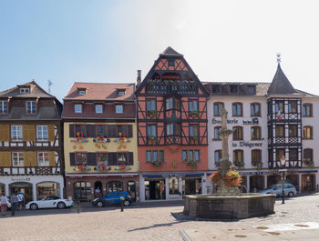 Houses by street against sky in city