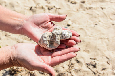 High angle view of woman hands holding sand