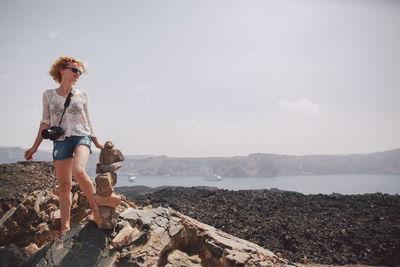 Rear view of woman standing on rock