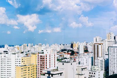 Buildings in city against cloudy sky