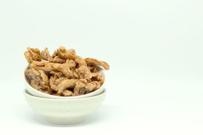 Close-up of bread in bowl against white background