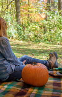 Low section of woman sitting on grass during halloween