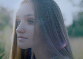 Close-up of the face of a young woman at dusk in the forest.