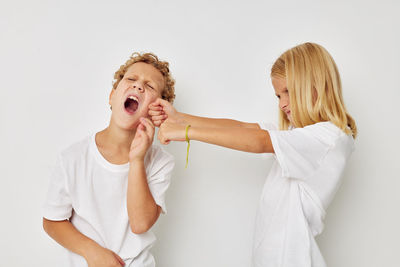 Sibling fighting against yellow background